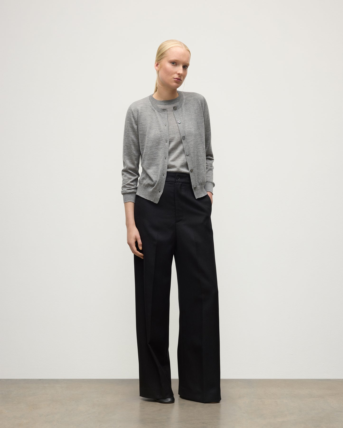 MODEL WEARING JOHNSTONS OF ELGIN WOMENS HONOR CREW CARDIGAN GREY 100% SUPERFINE CASHMERE OVER A MATCHING T-SHIRT WITH BLACK TROUSERS KAI05708HA4253