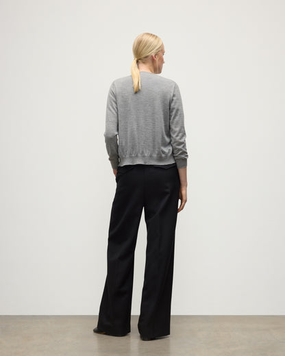 BACK OF A MODEL WEARING JOHNSTONS OF ELGIN WOMENS HONOR CREW CARDIGAN GREY 100% SUPERFINE CASHMERE OVER A MATCHING T-SHIRT WITH BLACK TROUSERS KAI05708HA4253