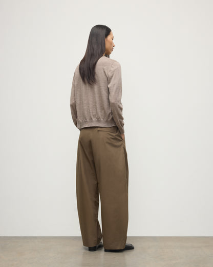 BACK OF MODEL WEARING JOHNSTONS OF ELGIN WOMENS HONOR CREW CARDIGAN LIGHT BROWN 100% SUPERFINE CASHMERE OVER A MATCHING CASHMERE T-SHIRT WITH BROWN WIDE LEG TROUSERS  KAI05708HB0273