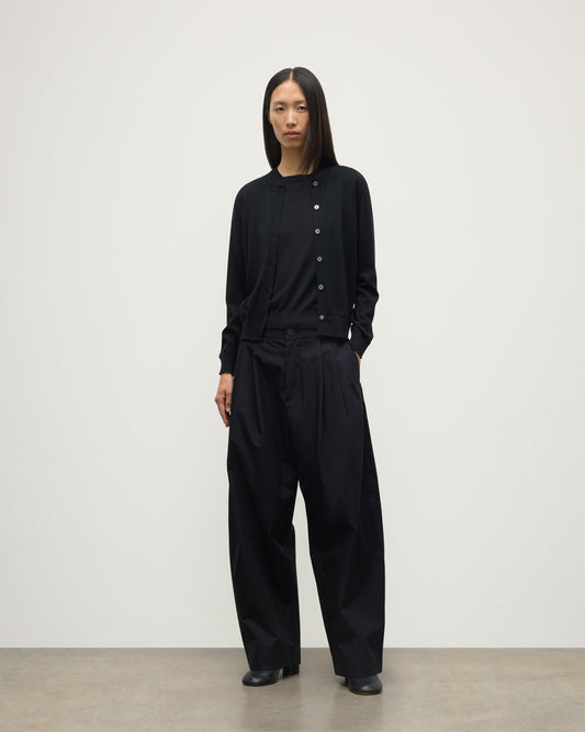 MODEL WEARING JOHNSTONS OF ELGIN WOMENS HONOR CREW CARDIGAN BLACK 100% SUPERFINE CASHMERE OVER A MATCHING T-SHIRT AND NAVY WIDE LEG TROUSERS KAI05708SA7146