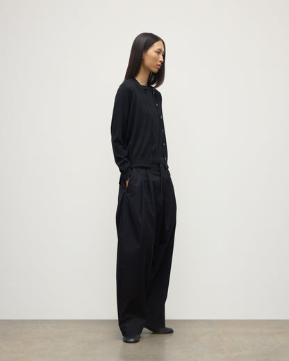 MODEL WEARING JOHNSTONS OF ELGIN WOMENS HONOR CREW CARDIGAN BLACK 100% SUPERFINE CASHMERE OVER A MATCHING T-SHIRT AND NAVY WIDE LEG TROUSERS KAI05708SA7146