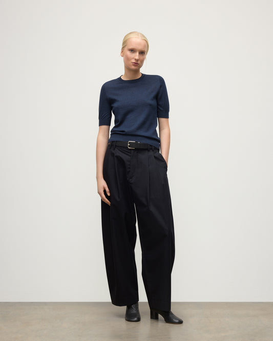 MODEL WEARS JOHNSTONS OF ELGIN WOMENS HONOR SHORT SLEEVE CREW NAVY 100% SUPERFINE CASHMERE WITH NAVY TROUSERS AND BLACK BOOTS KAI05712HD7350