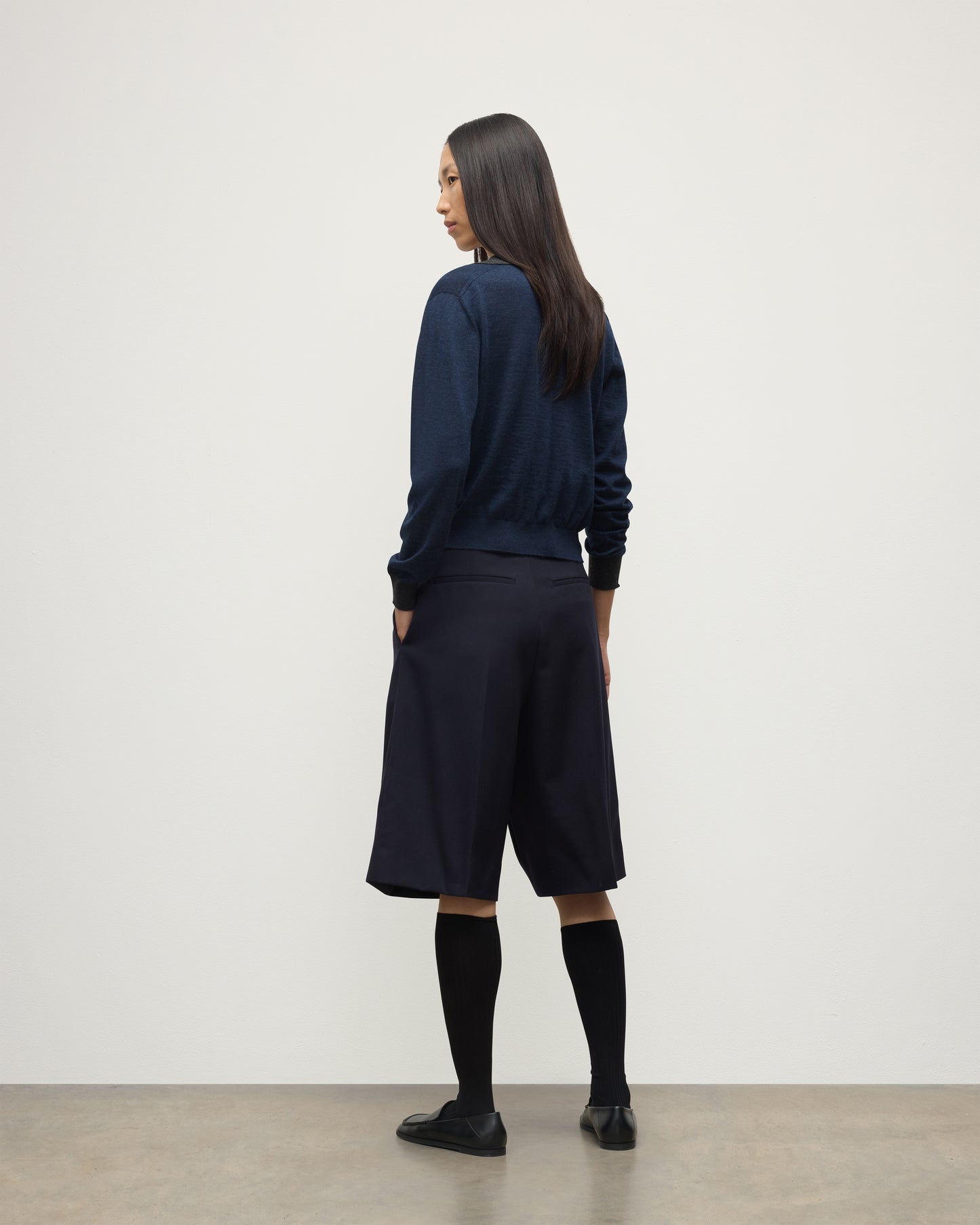 MODEL WEARS JOHNSTONS OF ELGIN WOMENS DEE SHIRT NAVY & GREY 100% SUPERFINE CASHMERE WITH NAVY LONG SHIRTS< SOCKS AND LOAFERS KAI05713Q25962