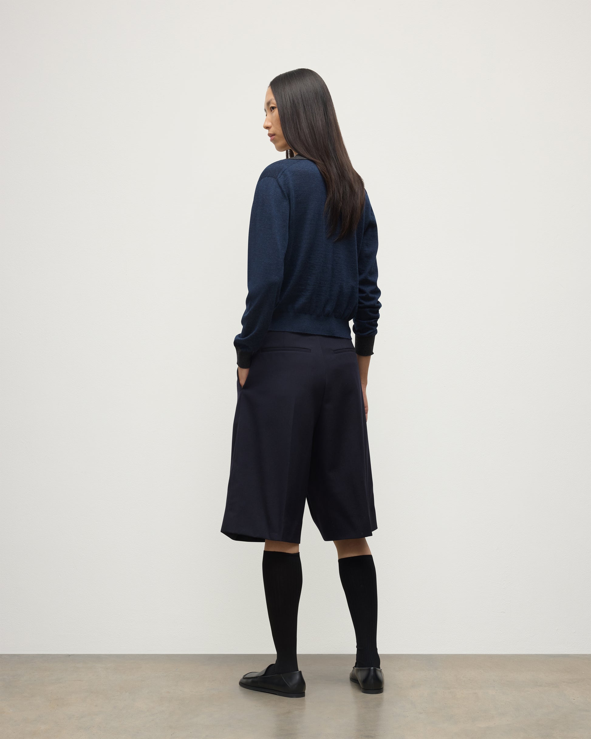 MODEL WEARS JOHNSTONS OF ELGIN WOMENS DEE SHIRT NAVY & GREY 100% SUPERFINE CASHMERE WITH NAVY LONG SHIRTS< SOCKS AND LOAFERS KAI05713Q25962