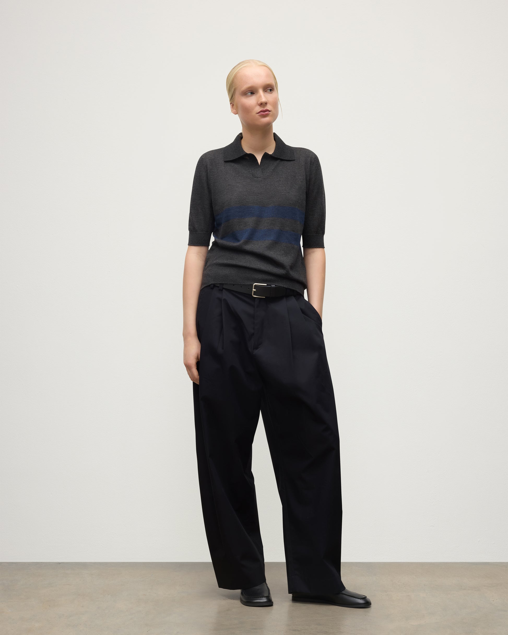 MODEL WEARS JOHNSTONS OF ELGIN WOMENS COIRA SHORT SLEEVE SHIRT GREY & NAVY 100% SUPERFINE CASHMERE WITH BLACK TROUSERS KAI05714Q25955