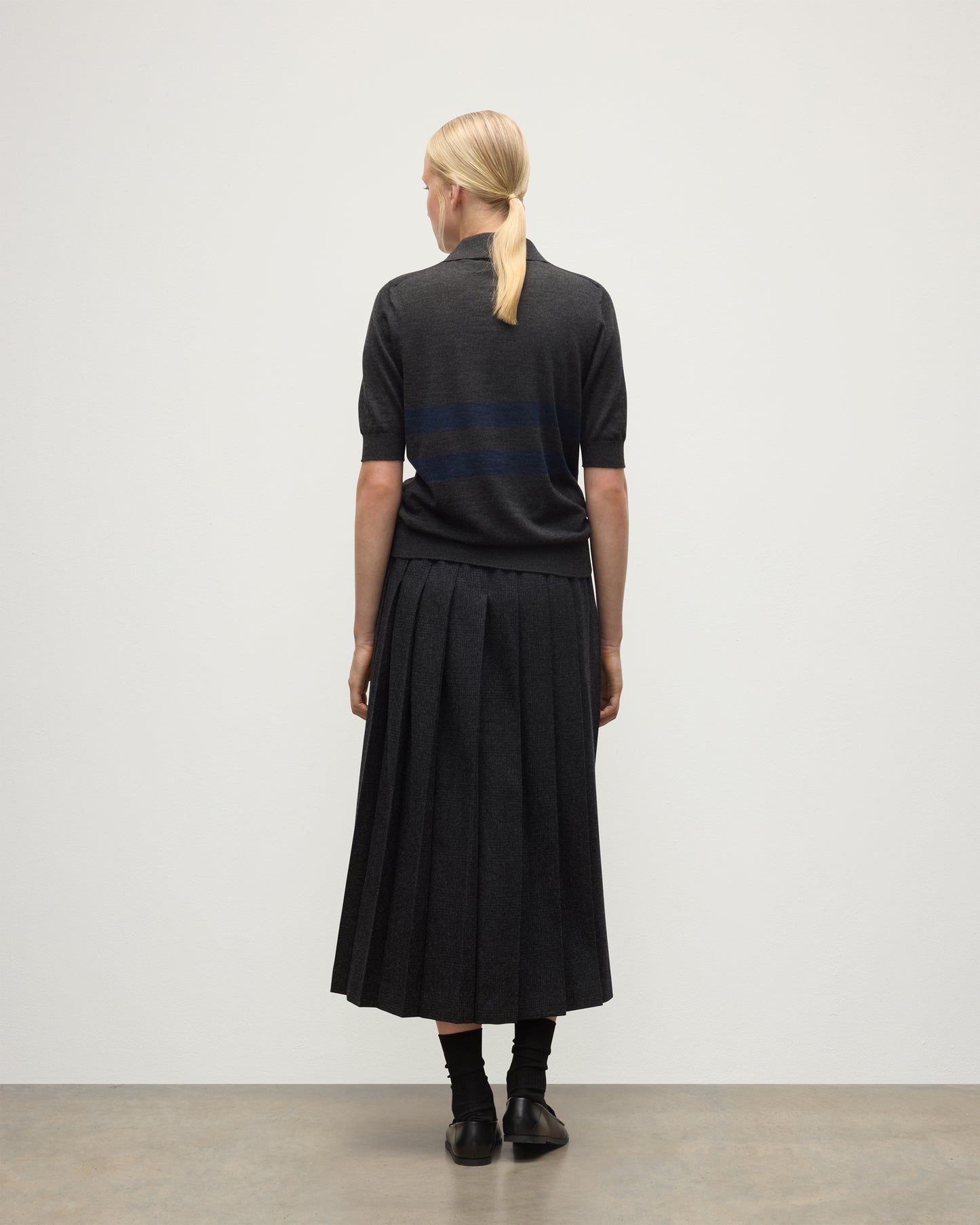 MODEL WEARS JOHNSTONS OF ELGIN WOMENS COIRA SHORT SLEEVE SHIRT GREY & NAVY 100% SUPERFINE CASHMERE WITH LE KILT CHARCOAL LONG KILT KAI05714Q25955