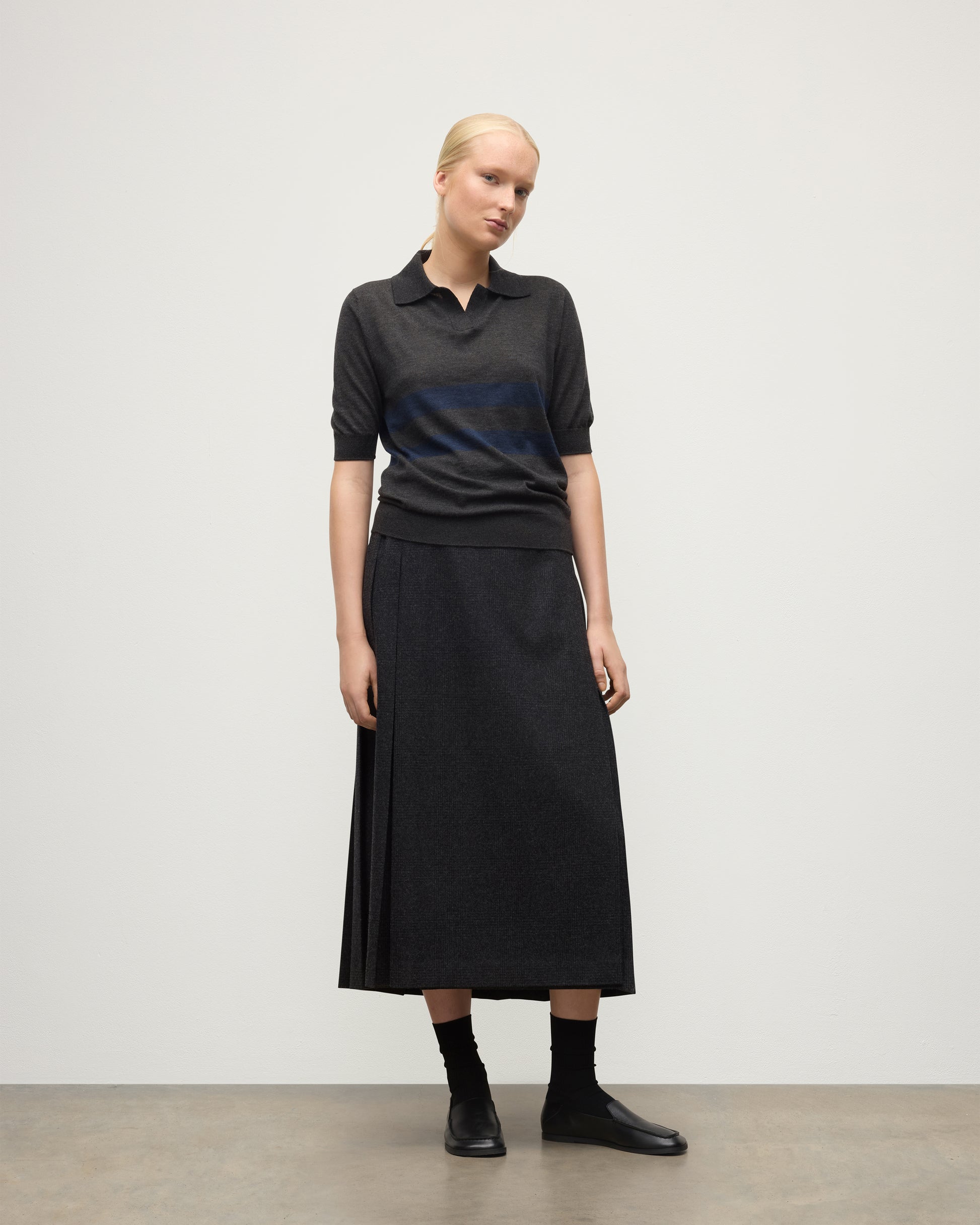 MODEL WEARS JOHNSTONS OF ELGIN WOMENS COIRA SHORT SLEEVE SHIRT GREY & NAVY 100% SUPERFINE CASHMERE WITH LE KILT CHARCOAL LONG KILT KAI05714Q25955