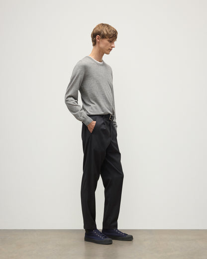 MODEL WEARS JOHNSTONS OF ELGIN MENS FIN SUPERFINE CREW GREY 100% SUPERFINE CASHMERE  OVER A WHITE T-SHIRT WITH GREY TROUSERS KAI05717HA4253