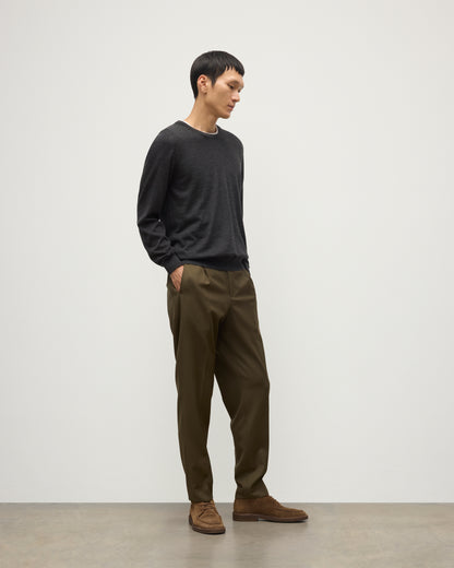 MODEL WEARS JOHNSTONS OF ELGIN MENS FIN SUPERFINE CREW GREY 100% SUPERFINE CASHMERE OVER A WHITE T-SHIRT WITH OLIVE GREEN TROUSERS KAI05717HA7218