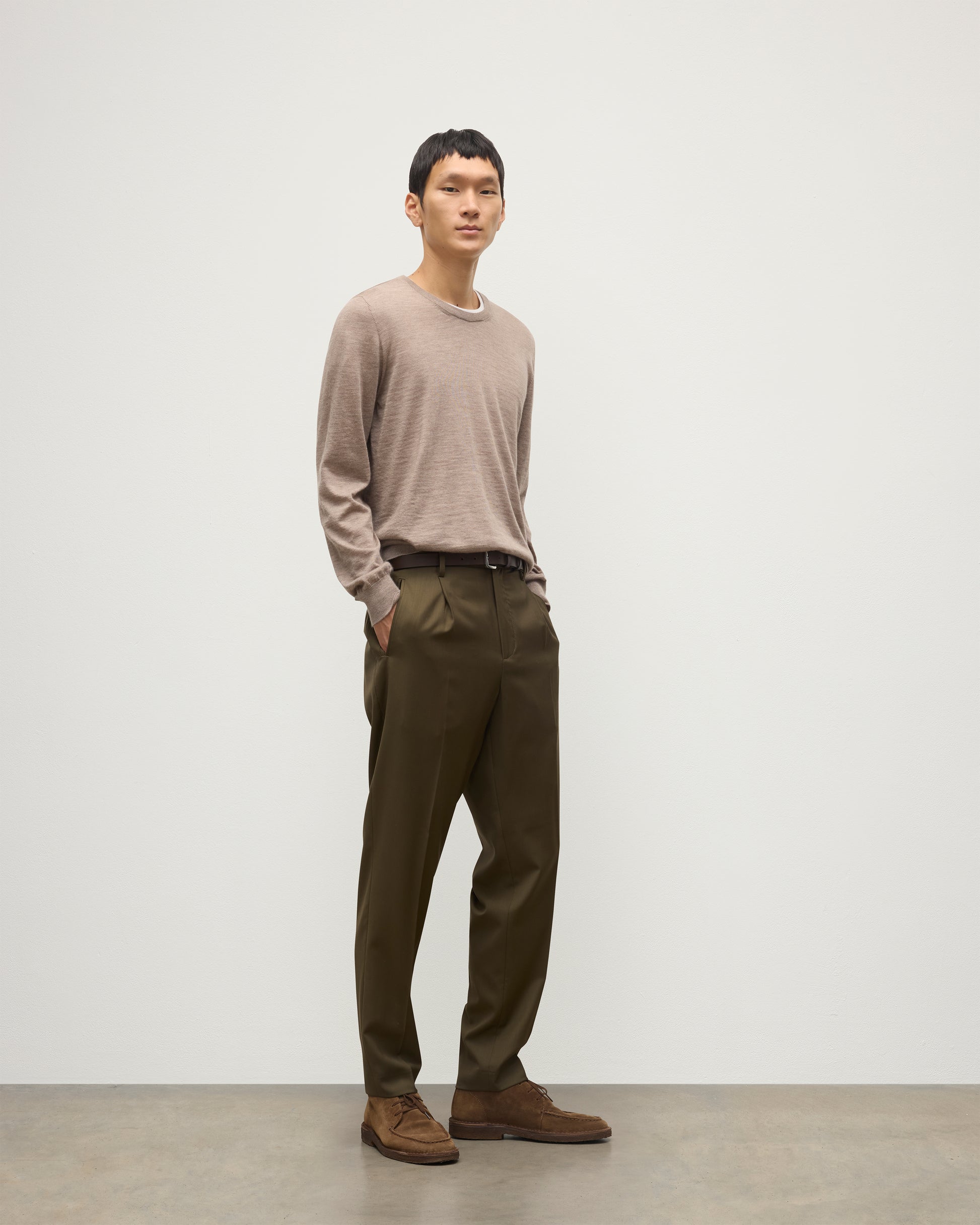 MODEL WEARS JOHNSTONS OF ELGIN MENS FIN SUPERFINE CREW LIGHT BROWN 100% SUPERFINE CASHMERE OVER A WHITE T-SHIRT WITH OLIVE GREEN TROUSERS  KAI05717HB0273