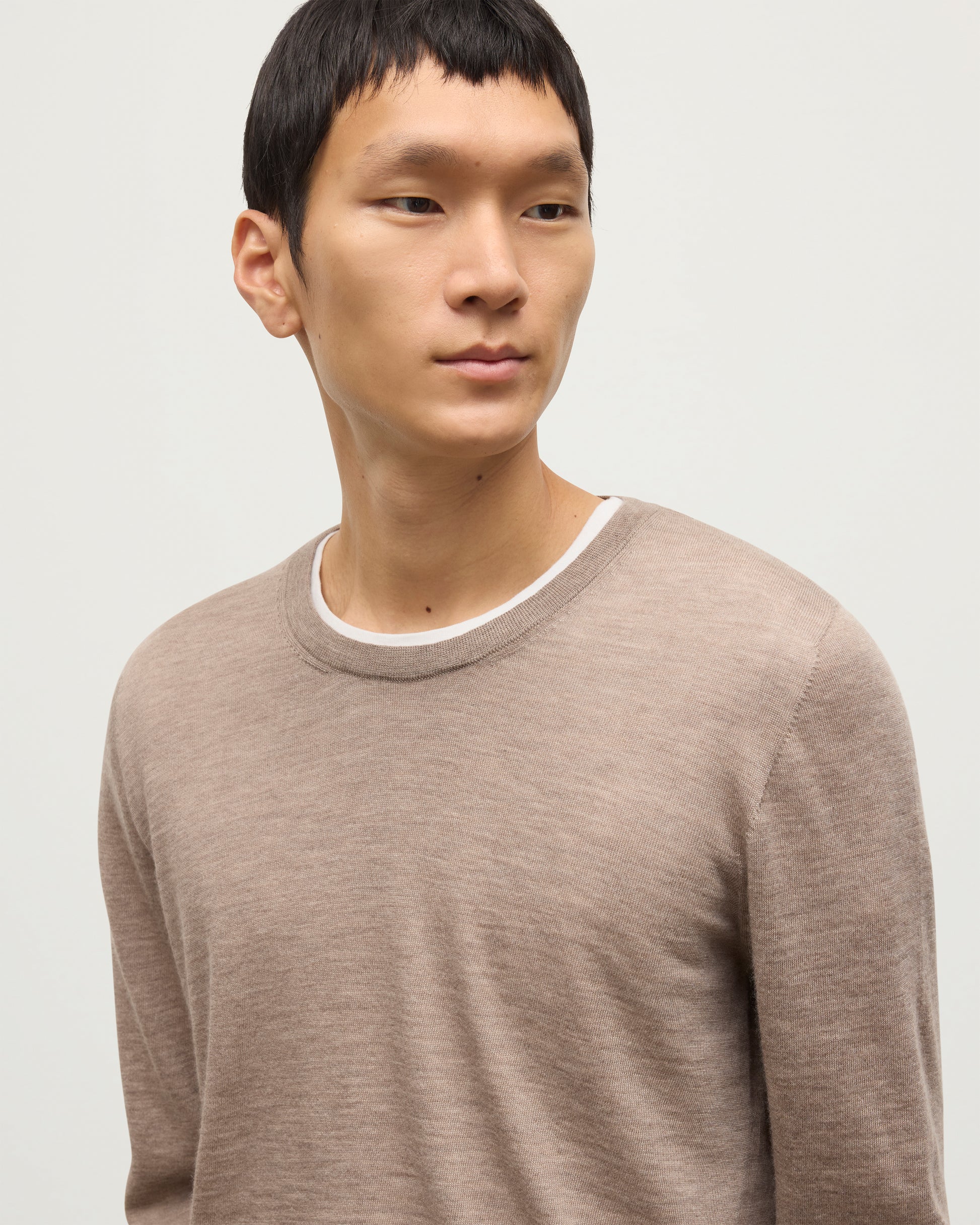 MODEL WEARS JOHNSTONS OF ELGIN MENS FIN SUPERFINE CREW LIGHT BROWN 100% SUPERFINE CASHMERE OVER A WHITE T-SHIRT  KAI05717HB0273