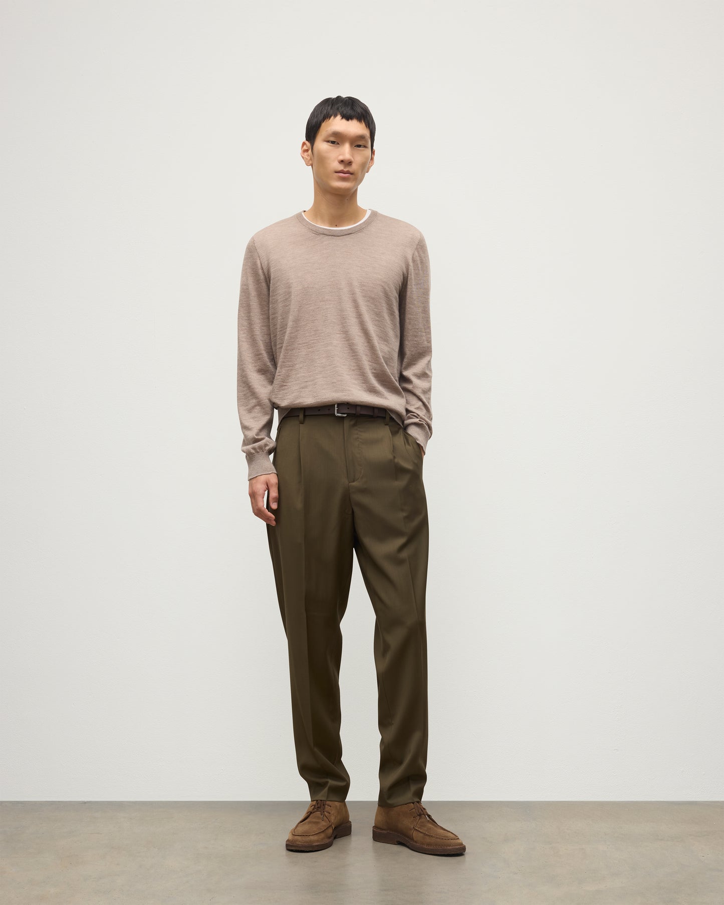 MODEL WEARS JOHNSTONS OF ELGIN MENS FIN SUPERFINE CREW LIGHT BROWN 100% SUPERFINE CASHMERE OVER A WHITE T-SHIRT WITH OLIVE GREEN TROUSERS  KAI05717HB0273