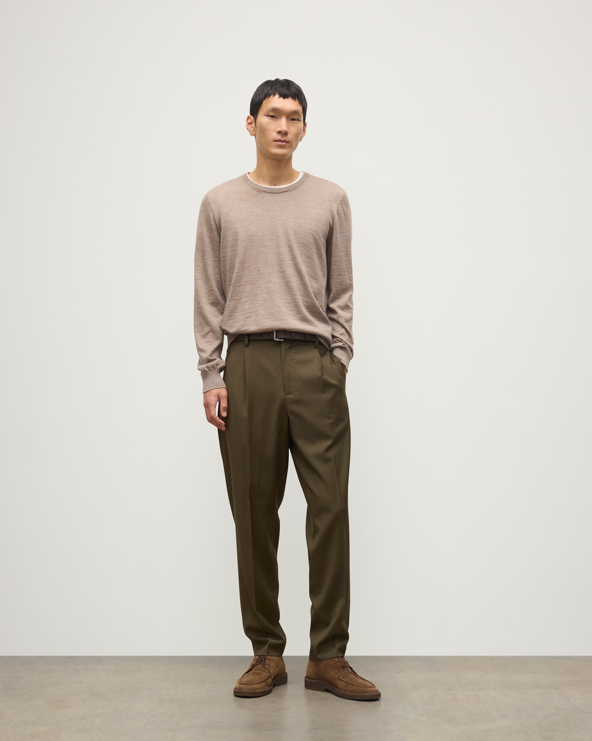 MODEL WEARS JOHNSTONS OF ELGIN MENS FIN SUPERFINE CREW LIGHT BROWN 100% SUPERFINE CASHMERE OVER A WHITE T-SHIRT WITH OLIVE GREEN TROUSERS  KAI05717HB0273