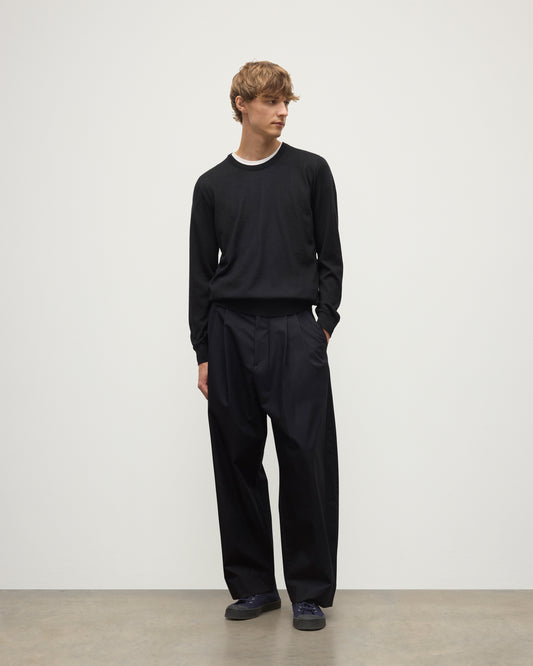 MODEL WEARS JOHNSTONS OF ELGIN MENS FIN SUPERFINE CREW BLACK 100% SUPERFINE CASHMERE OVER A WHITE T-SHIRT WITH BLACK TROUSERS KAI05717SA7146