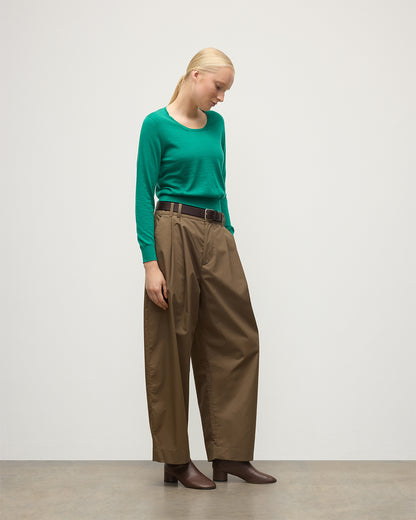 MODEL WEARS JOHNSTONS OF ELGIN WOMENS ELLA SCOOP SWEATER GREEN 100% SUPERFINE CASHMERE WITH BROWN WIDE LEG TROUSERS  KAI05723SC4714