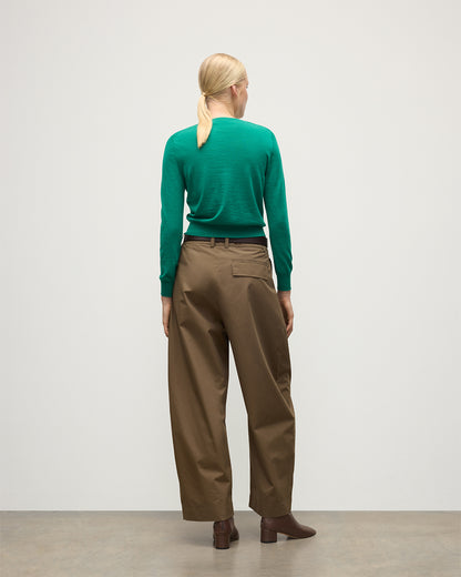 MODEL WEARS JOHNSTONS OF ELGIN WOMENS ELLA SCOOP SWEATER GREEN 100% SUPERFINE CASHMERE WITH BROWN WIDE LEG TROUSERS  KAI05723SC4714