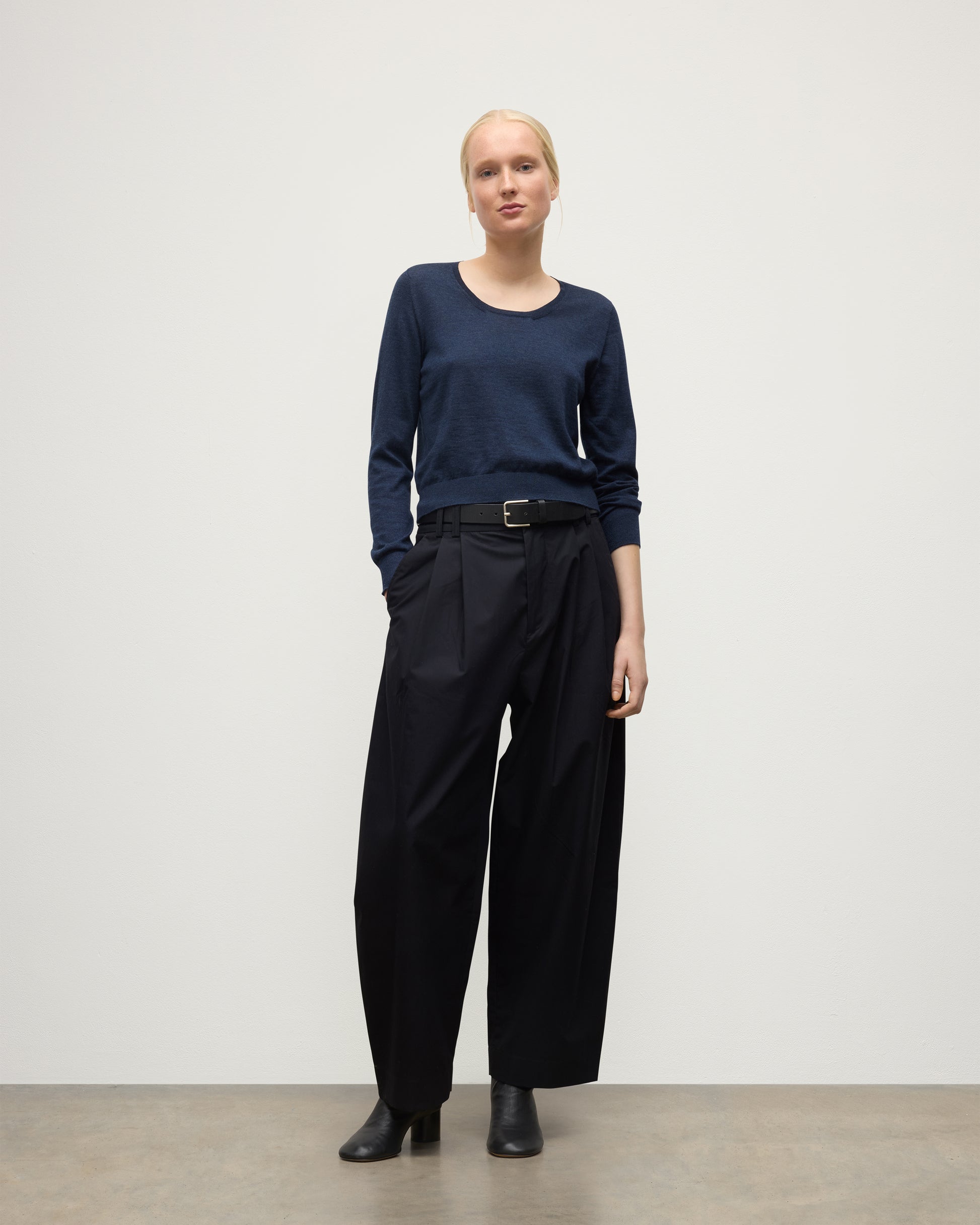 MODEL WEARING JOHNSTONS OF ELGIN WOMENS ELLA SCOOP SWEATER NAVY WITH BLACK TROUSERS AND BOOTS KAI05723HD7350