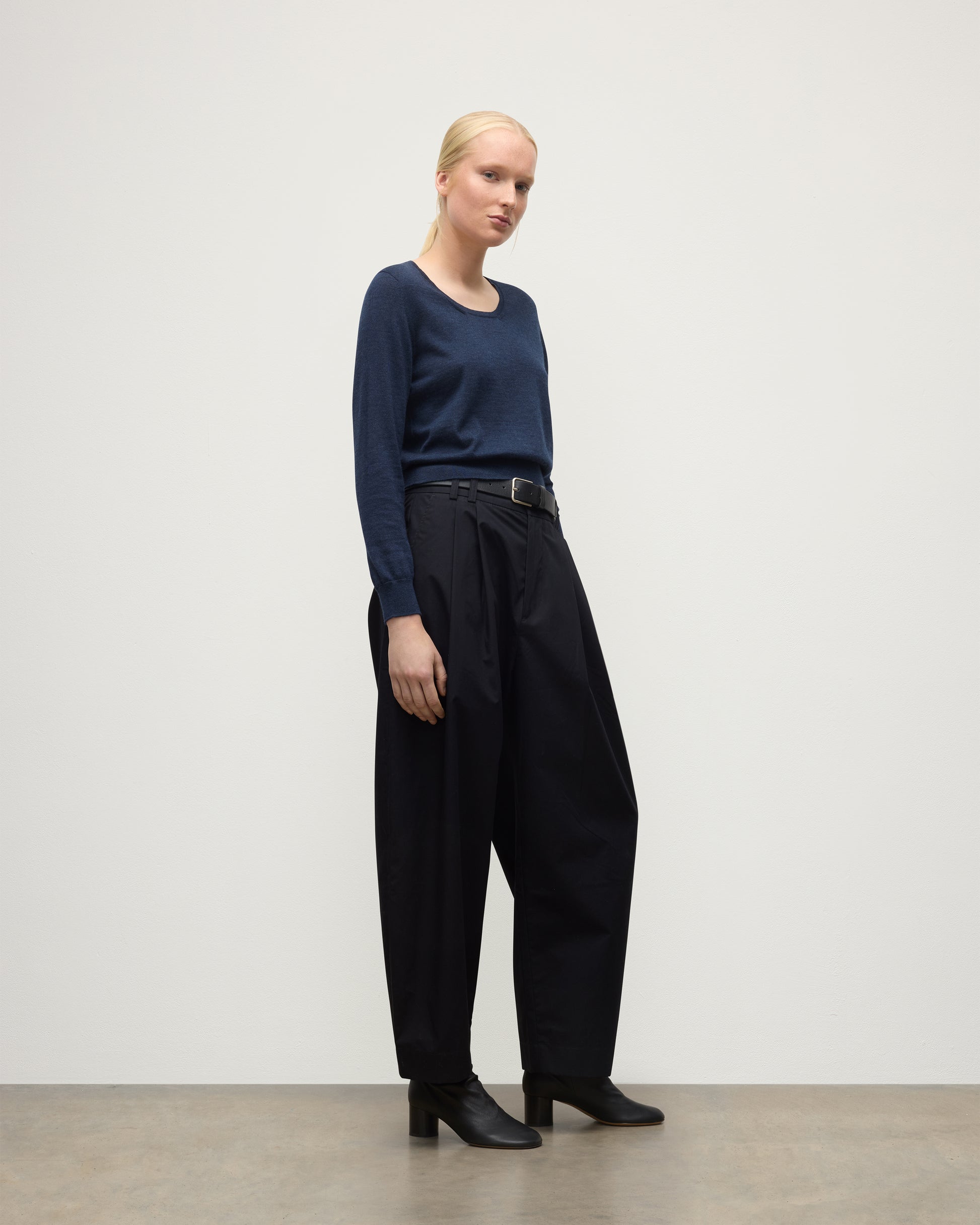 MODEL WEARING JOHNSTONS OF ELGIN WOMENS ELLA SCOOP SWEATER NAVY WITH BLACK TROUSERS AND BOOTS KAI05723HD7350