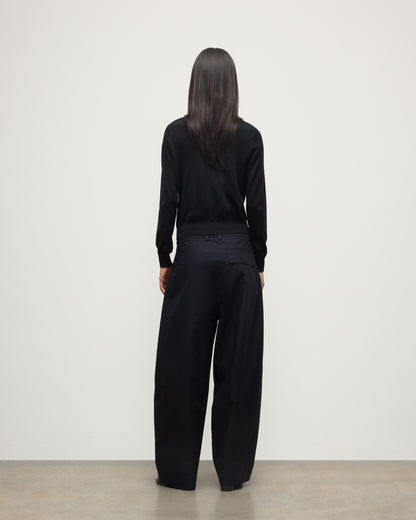 BACK VIEW OF MODEL WEARING JOHNSTONS OF ELGIN WOMENS ELLA SCOOP SWEATER BLACK WITH BLACK TROUSERS KAI05723SA7146