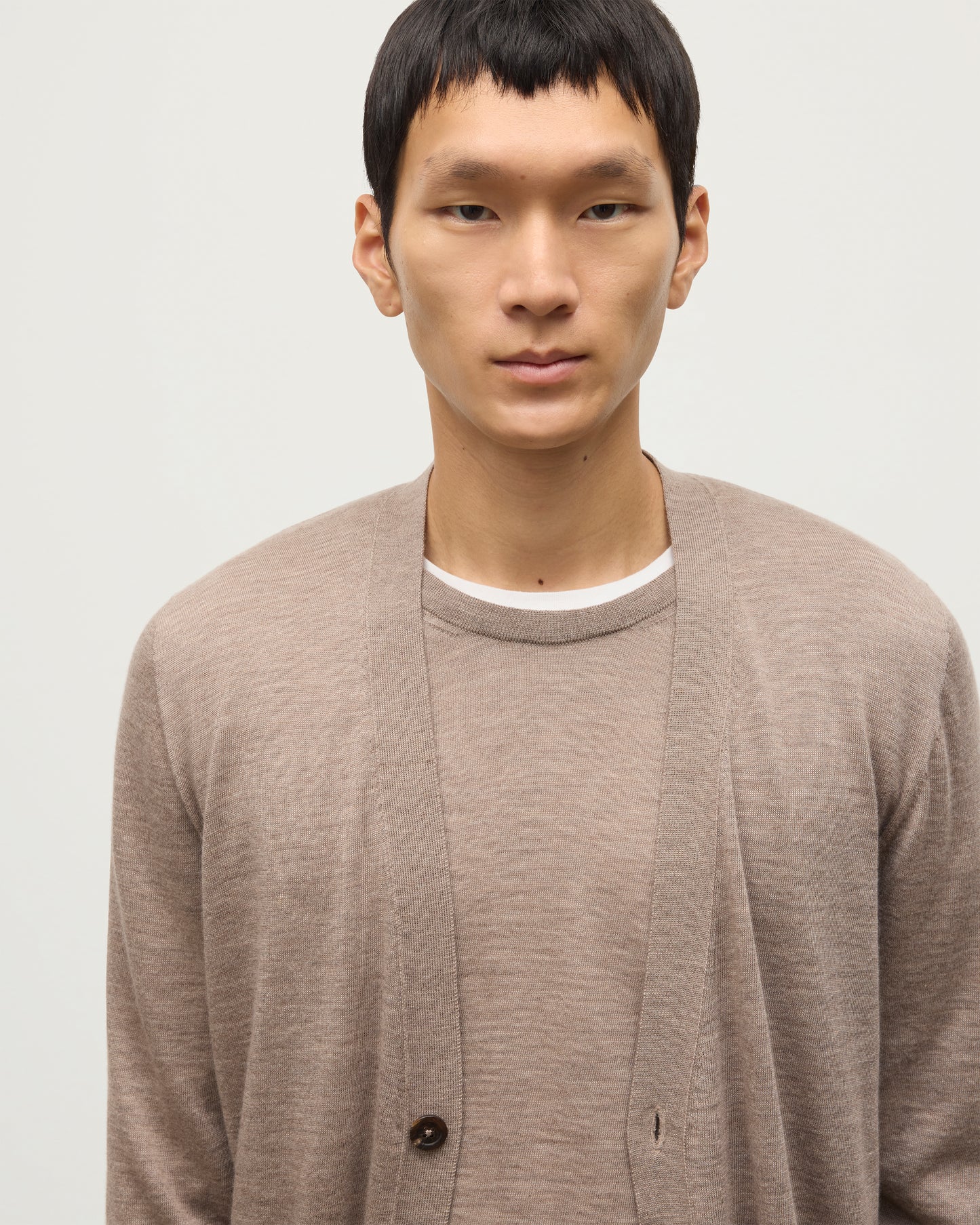 MALE MODEL WEARING JOHNSTONS OF ELGIN FORSYTH SUPERFINE VEE NECK CARDIGAN LIGHT BROWN  OVER A MATCHING SUPERFINE CASHMERE SWEATER KAI05740HB0273