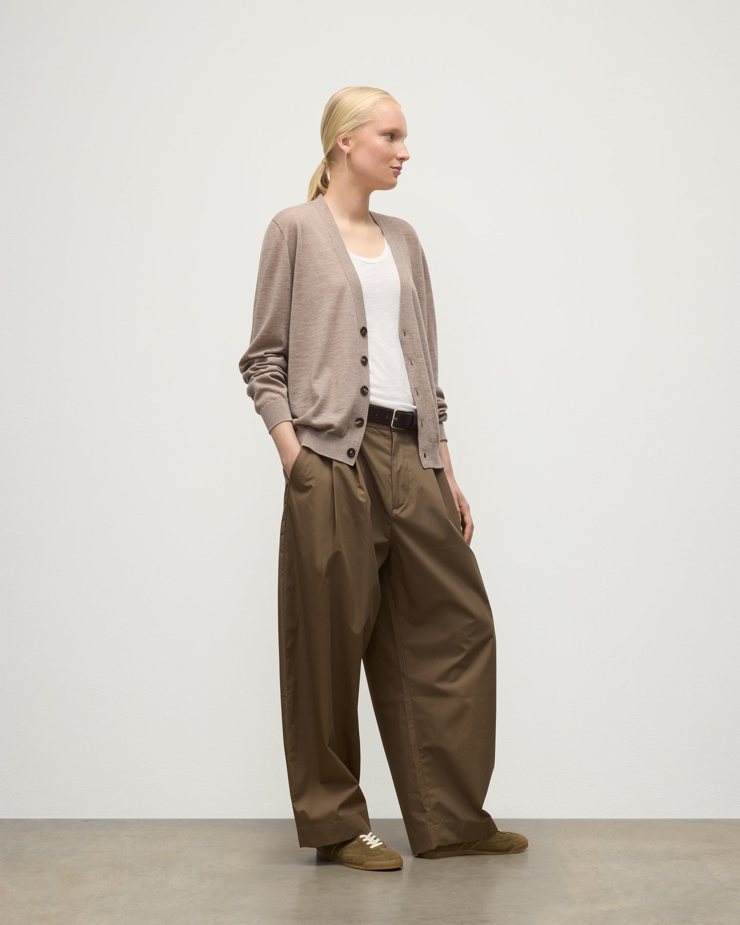 FEMALE MODEL WEARING JOHNSTONS OF ELGIN FORSYTH SUPERFINE VEE NECK CARDIGAN LIGHT BROWN WITH BROWN WIDE LEG TROUSERS KAI05740HB0273