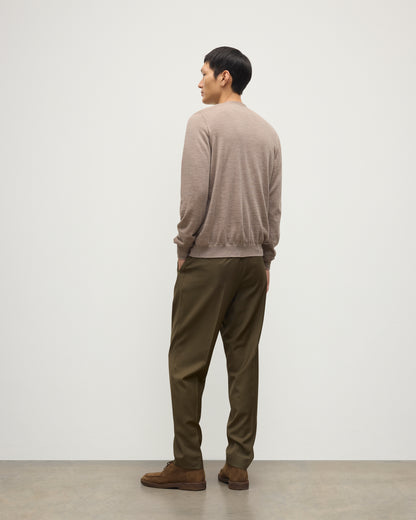 MALE MODEL WEARING JOHNSTONS OF ELGIN FORSYTH SUPERFINE VEE NECK CARDIGAN LIGHT BROWN  OVER A MATCHING SUPERFINE CASHMERE SWEATER AND OLIVE TROUSERS KAI05740HB0273