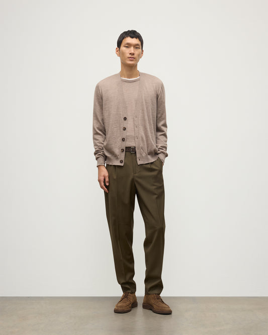MALE MODEL WEARING JOHNSTONS OF ELGIN FORSYTH SUPERFINE VEE NECK CARDIGAN LIGHT BROWN  OVER A MATCHING SUPERFINE CASHMERE SWEATER AND OLIVE TROUSERS KAI05740HB0273