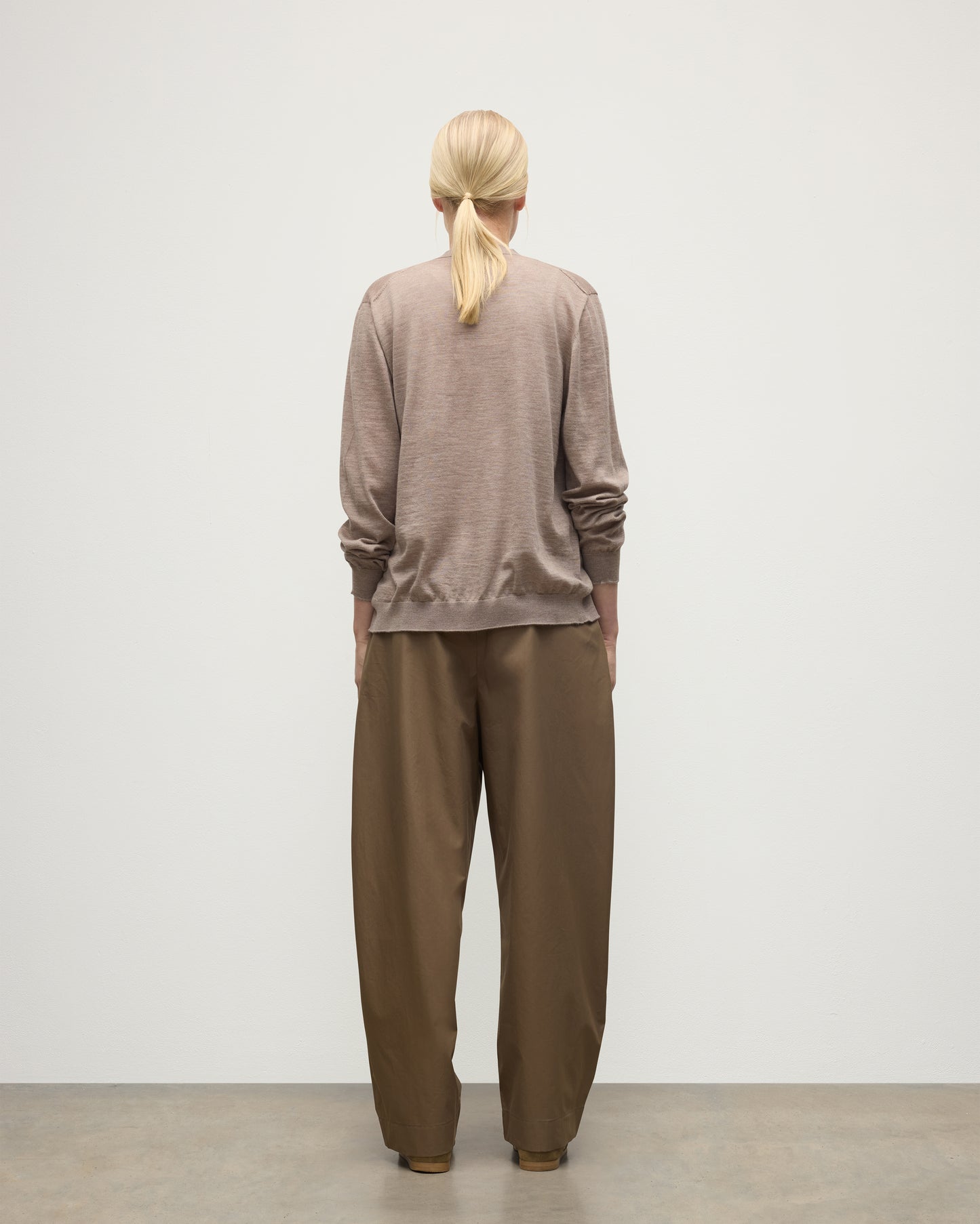 FEMALE MODEL WEARING JOHNSTONS OF ELGIN FORSYTH SUPERFINE VEE NECK CARDIGAN LIGHT BROWN WITH BROWN WIDE LEG TROUSERS KAI05740HB0273