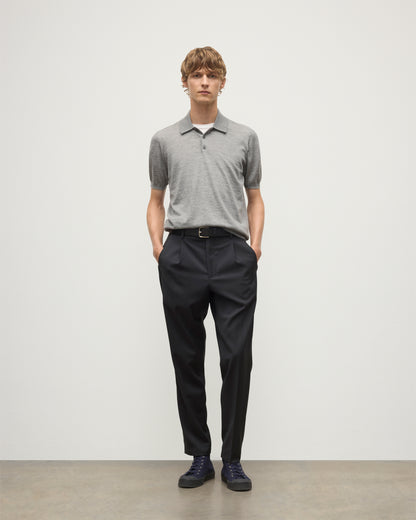 MODEL WEARS JOHNSTONS OF ELGIN MENS FIN SHORT SLEEVE SUPERFINE POLOSHIRT GREY OVER A WHITE T-SHIRT WITH NAVY TROUSERS KAI05741HA4253