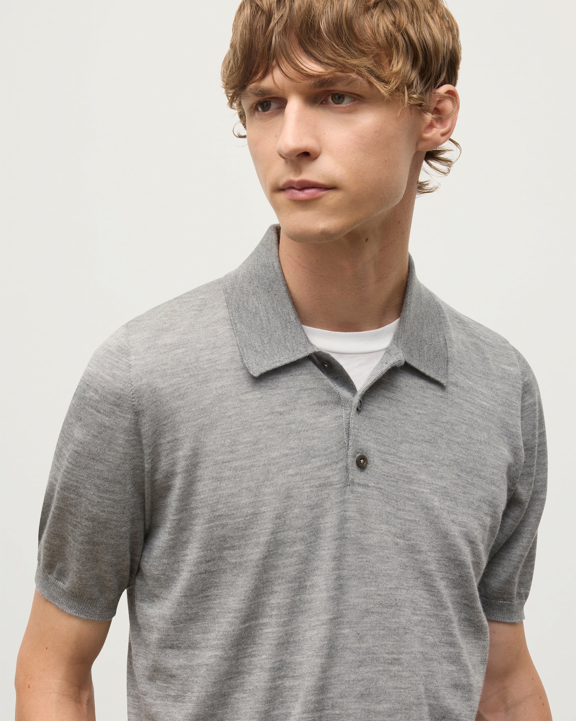 MODEL WEARS JOHNSTONS OF ELGIN MENS FIN SHORT SLEEVE SUPERFINE POLOSHIRT GREY OVER A WHITE T-SHIRT KAI05741HA4253