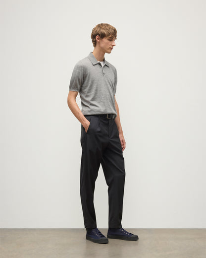 MODEL WEARS JOHNSTONS OF ELGIN MENS FIN SHORT SLEEVE SUPERFINE POLOSHIRT GREY OVER A WHITE T-SHIRT WITH NAVY TROUSERS KAI05741HA4253