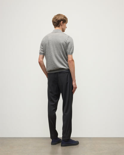 MODEL WEARS JOHNSTONS OF ELGIN MENS FIN SHORT SLEEVE SUPERFINE POLOSHIRT GREY OVER A WHITE T-SHIRT WITH NAVY TROUSERS KAI05741HA4253