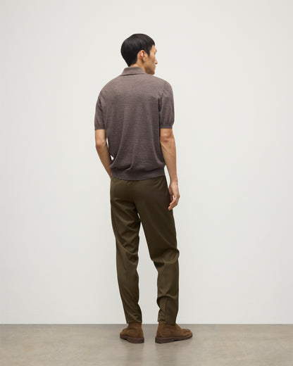 MODEL WEARS JOHNSTONS OF ELGIN MENS FIN SHORT SLEEVE SUPERFINE POLOSHIRT LIGHT BROWN OVER A WHITE T-SHIRT WITH OLIVE GREEN TROUSERS KAI05741HB7092