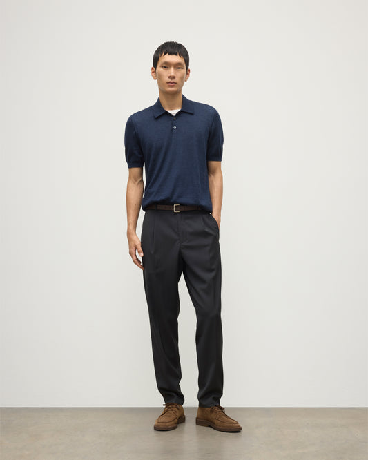 MODEL WEARS JOHNSTONS OF ELGIN MENS FIN SHORT SLEEVE SUPERFINE POLOSHIRT NAVY OVER A WHITE T-SHIRT WITH NAVY TROUSERS KAI05741HD7350