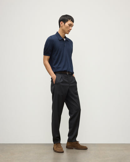 MODEL WEARS JOHNSTONS OF ELGIN MENS FIN SHORT SLEEVE SUPERFINE POLOSHIRT NAVY OVER A WHITE T-SHIRT WITH NAVY TROUSERS KAI05741HD7350