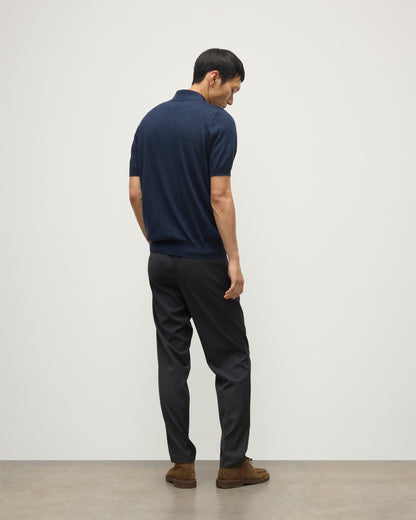 MODEL WEARS JOHNSTONS OF ELGIN MENS FIN SHORT SLEEVE SUPERFINE POLOSHIRT NAVY OVER A WHITE T-SHIRT WITH NAVY TROUSERS KAI05741HD7350