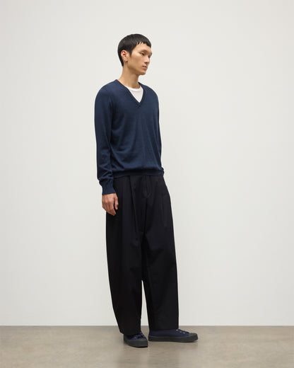 MENS FIN SUPERFINE VEE NECK NAVY 100% SUPERFINE CASHMERE BY JOHNSTONS OF ELGIN, WORN OVER A WHITE T-SHIRT WITH NAVY TROUSERS KAI05744HD7350