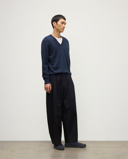 MENS FIN SUPERFINE VEE NECK NAVY 100% SUPERFINE CASHMERE BY JOHNSTONS OF ELGIN, WORN OVER A WHITE T-SHIRT WITH NAVY TROUSERS KAI05744HD7350