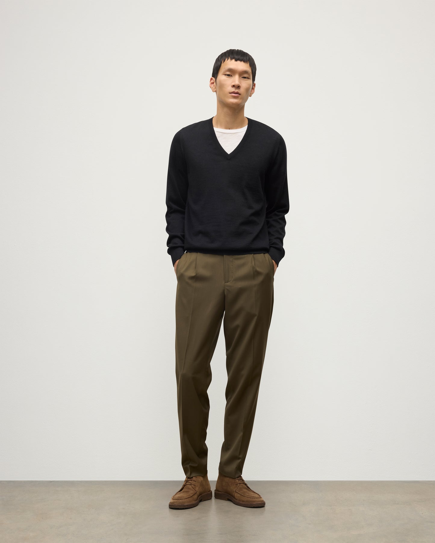 MENS FIN SUPERFINE VEE NECK BLACK 100% SUPERFINE CASHMERE BY JOHNSTONS OF ELGIN, OVER A WHITE T-SHIRT WITH OLIVE GREEN TROUSERS KAI05744SA7146