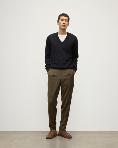 MENS FIN SUPERFINE VEE NECK BLACK 100% SUPERFINE CASHMERE BY JOHNSTONS OF ELGIN, OVER A WHITE T-SHIRT WITH OLIVE GREEN TROUSERS KAI05744SA7146