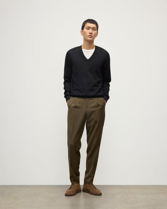 MENS FIN SUPERFINE VEE NECK BLACK 100% SUPERFINE CASHMERE BY JOHNSTONS OF ELGIN, OVER A WHITE T-SHIRT WITH OLIVE GREEN TROUSERS KAI05744SA7146