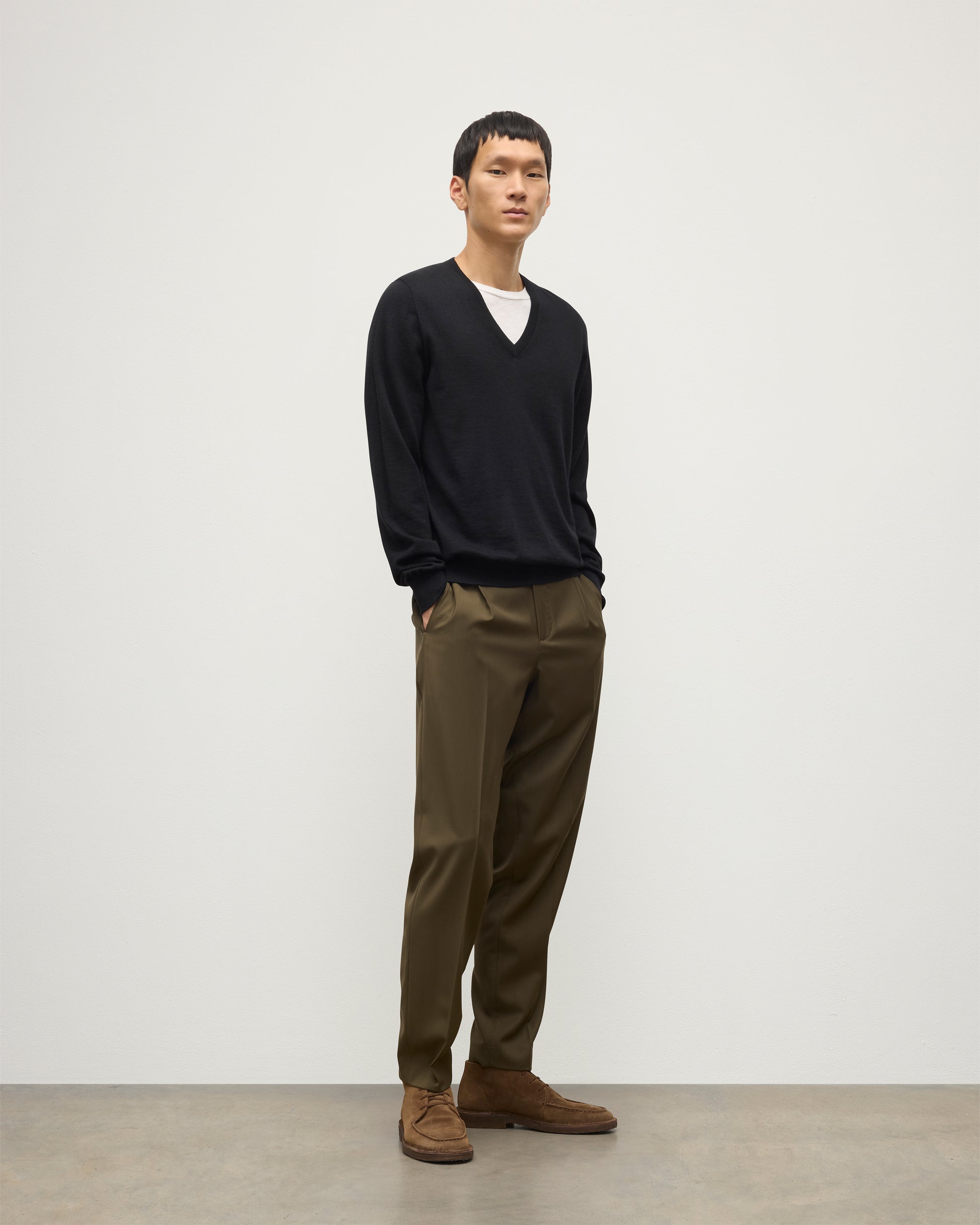 MENS FIN SUPERFINE VEE NECK BLACK 100% SUPERFINE CASHMERE BY JOHNSTONS OF ELGIN, OVER A WHITE T-SHIRT WITH OLIVE GREEN TROUSERS KAI05744SA7146