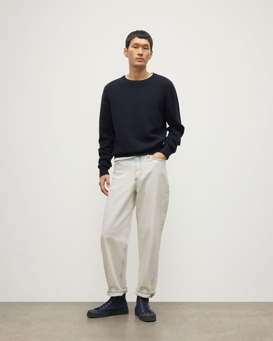 MODEL WEARS JOHNSTONS OF ELGIN  MENS TIREE CREW SWEATER BLUE 100% DONEGAL CASHMERE WITH WHITE JEANS KAI05755HD7348