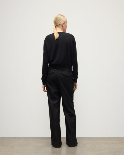 BACK OF JOHNSTONS OF ELGIN WOMENS FINOLA SWEATER BLACK 100% SUPERFINE CASHMERE ON A MODEL WITH BLACK TROUSERS AND BOOTS KAI05789SA7146