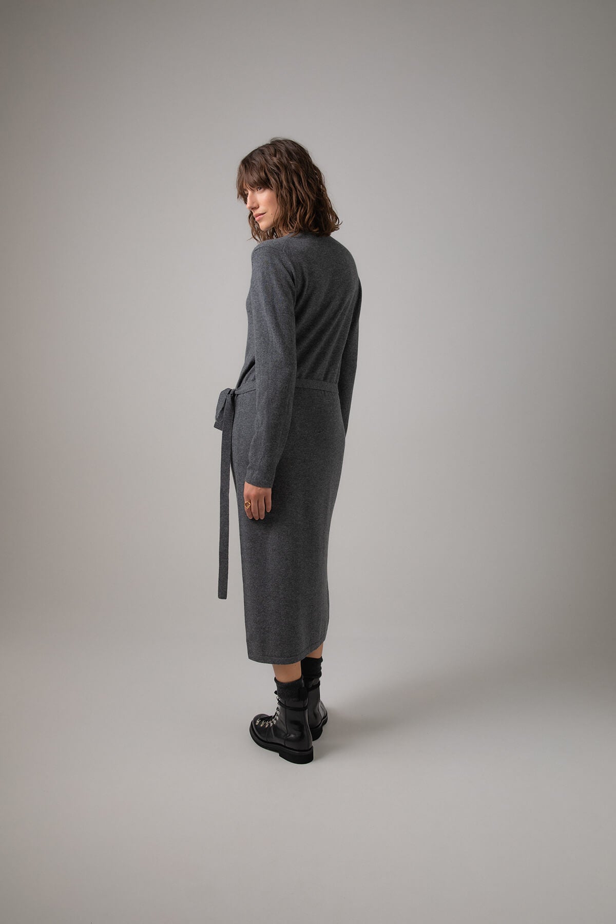 Back of Johnstons of Elgin Ballet Wrap Cashmere Dress in Mid Grey worn with Cashmere Socks & Shoes on a grey background KAP05047HA4181