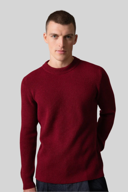 Johnstons of Elgin Men’s Ribbed Cashmere Round Neck Jumper in Wine on model wearing navy trousers on grey background KAP05144SE6162