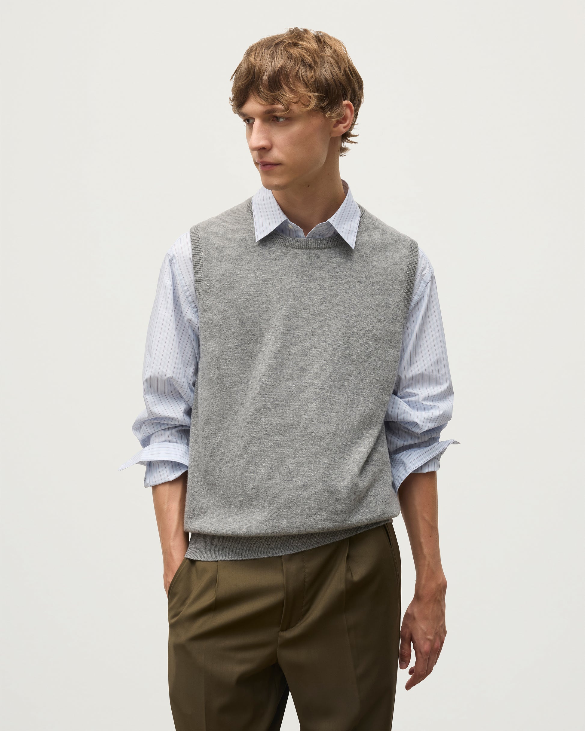 MODEL WEARS JOHNSTONS OF ELGIN MENS LENNOX SLEEVELESS CREW GREY 100% CASHMERE KAP05243HA0400