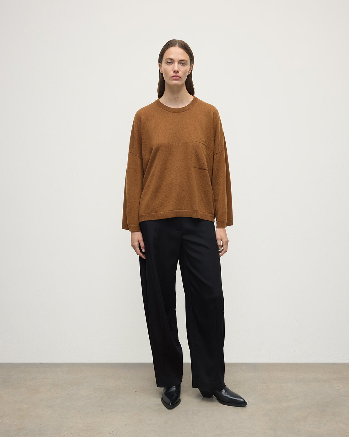 Model wears Johnstons of Elgin AW25 Women's Knitwear Dark Camel Gauzy Pocket Camel Cashmere Jumper Front View KAP05315SB4620