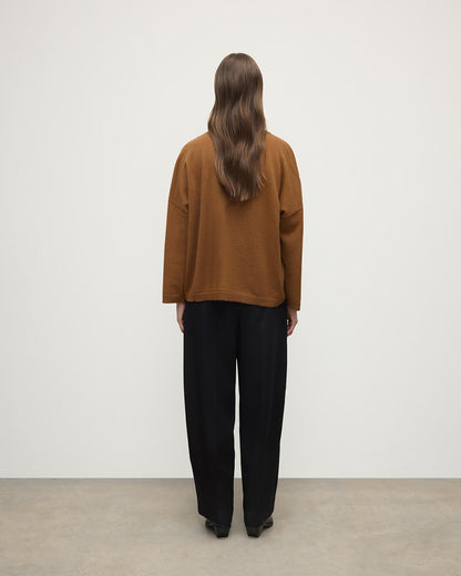 Model wears Johnstons of Elgin AW25 Women's Knitwear Dark Camel Gauzy Pocket Camel Cashmere Jumper Back View KAP05315SB4620