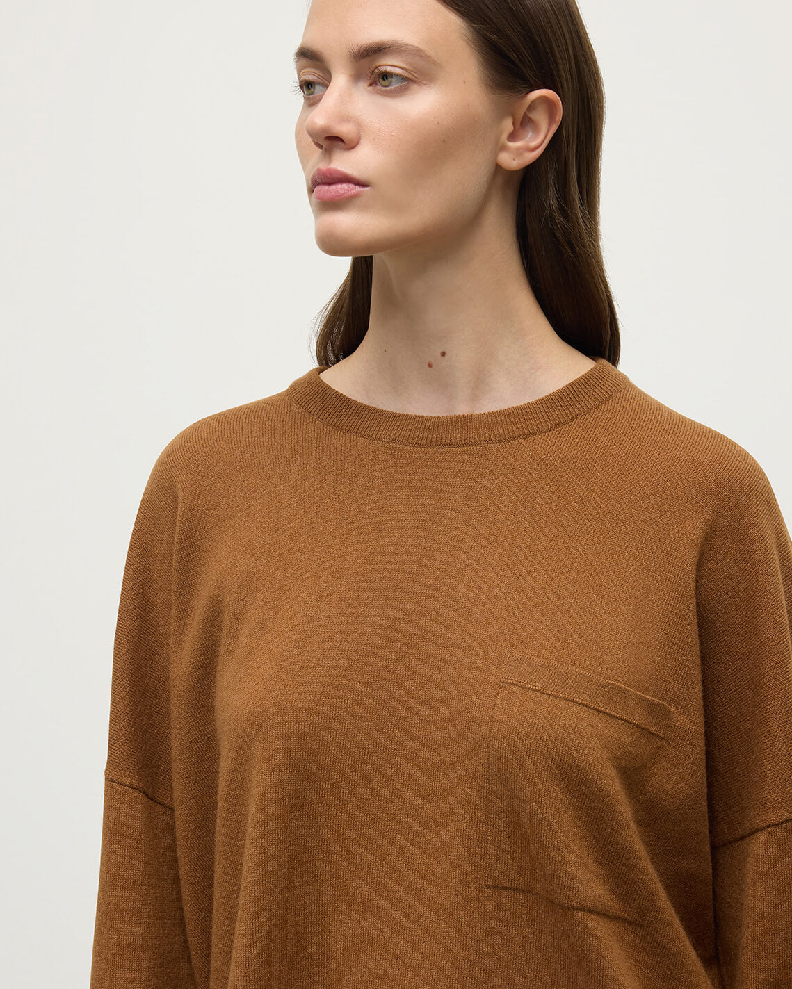 Model wears Johnstons of Elgin AW25 Women's Knitwear Dark Camel Gauzy Pocket Camel Cashmere Jumper Pocket details KAP05315SB4620